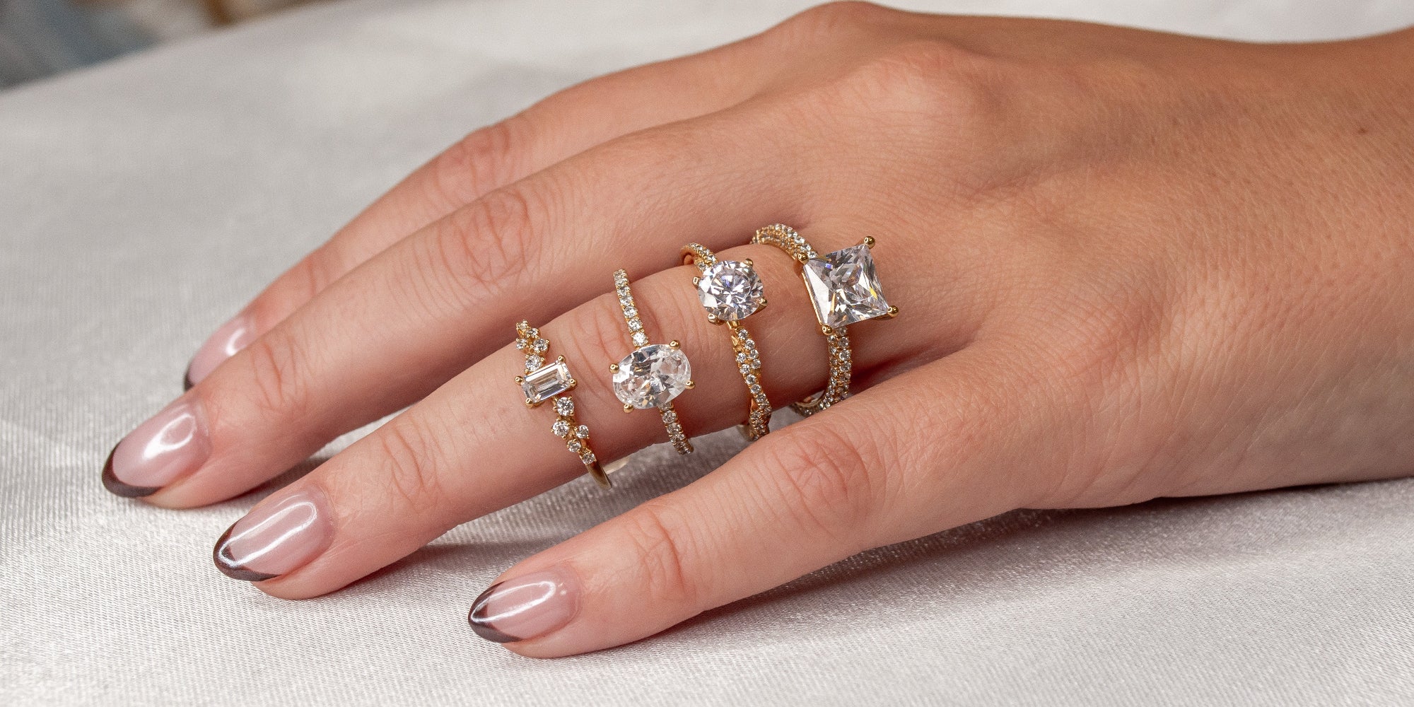 Multiple diamond engagement rings on model hand | Lisa Robin