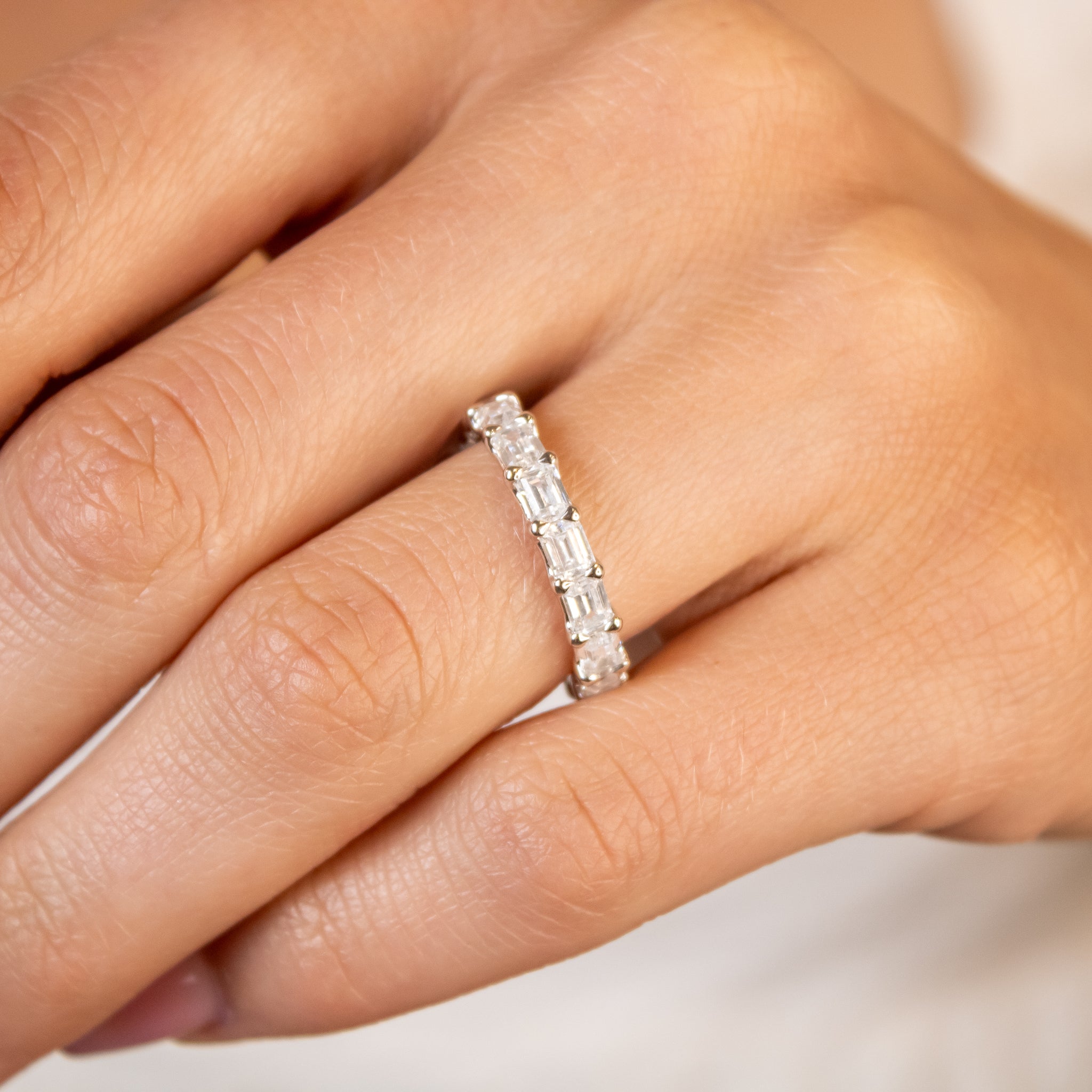 Avery east west emerald cut lab grown eternity 14K yellow gold wedding band on model hand by Lisa Robin#color_14k-yellow-gold