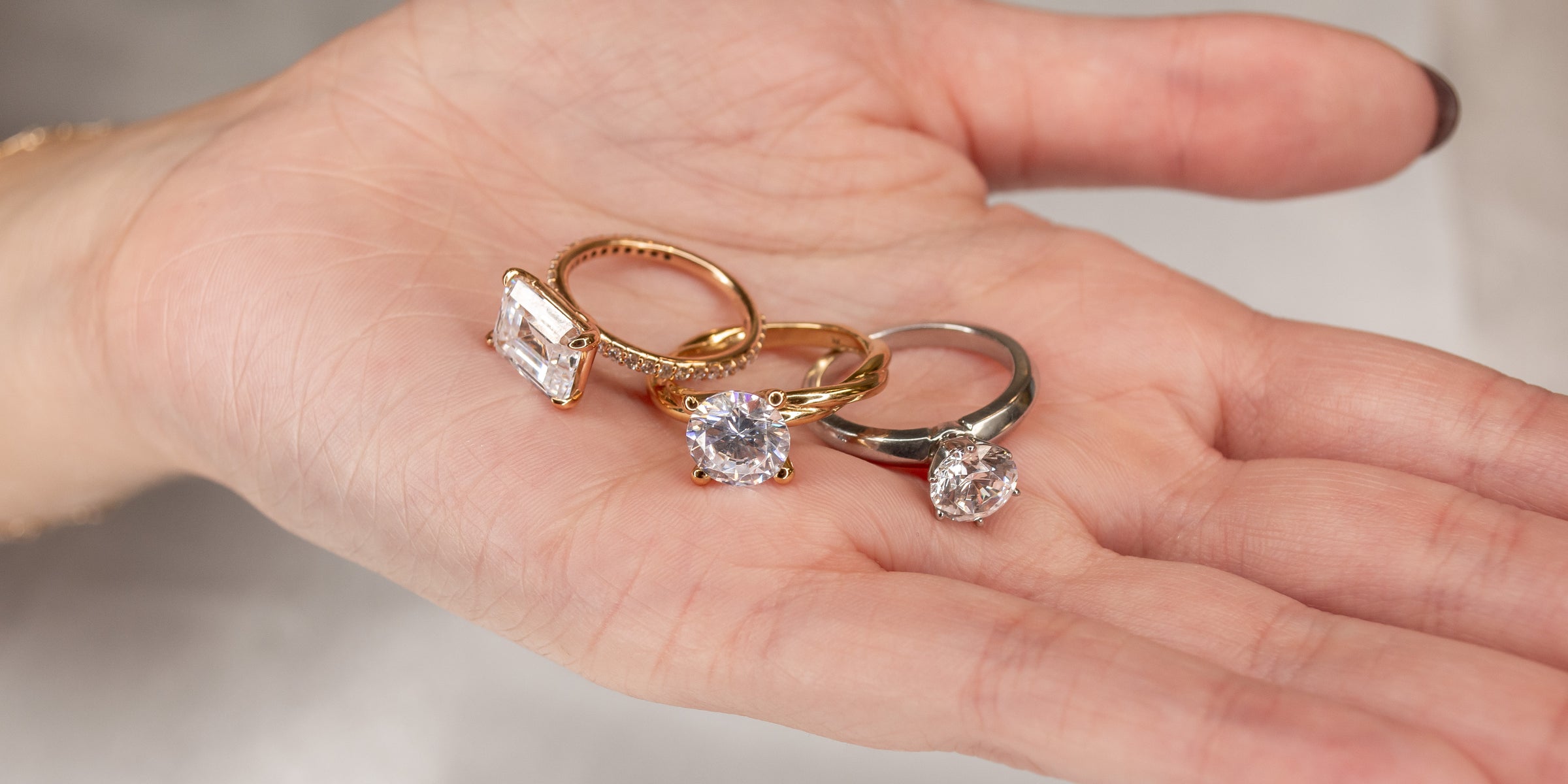 Engagement rings in the palm of hand showing rose gold,white gold, yellow gold | Lisa Robin