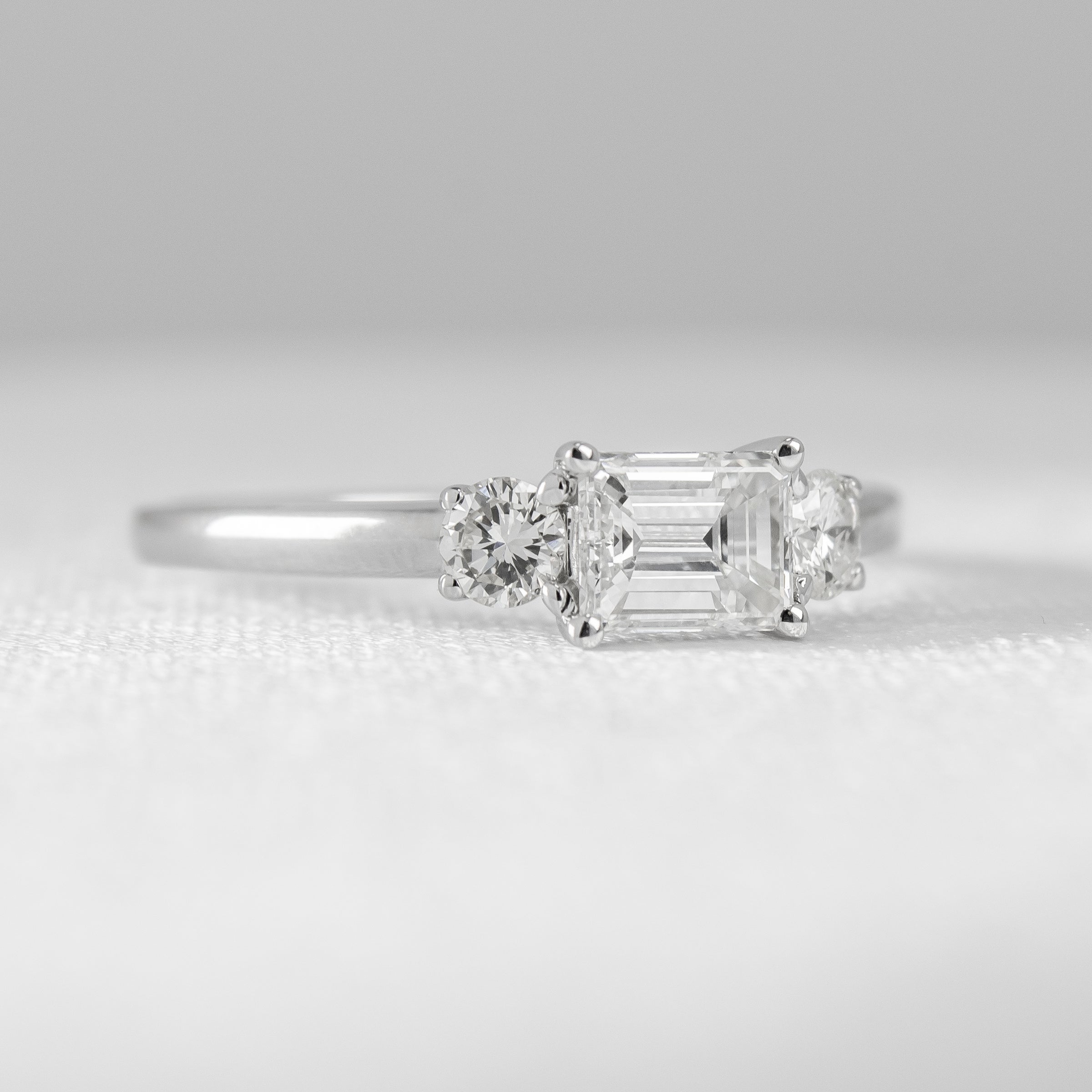Custom East West Emerald Diamond Engagement Ring with Side Diamonds in White Gold | Lisa Robin