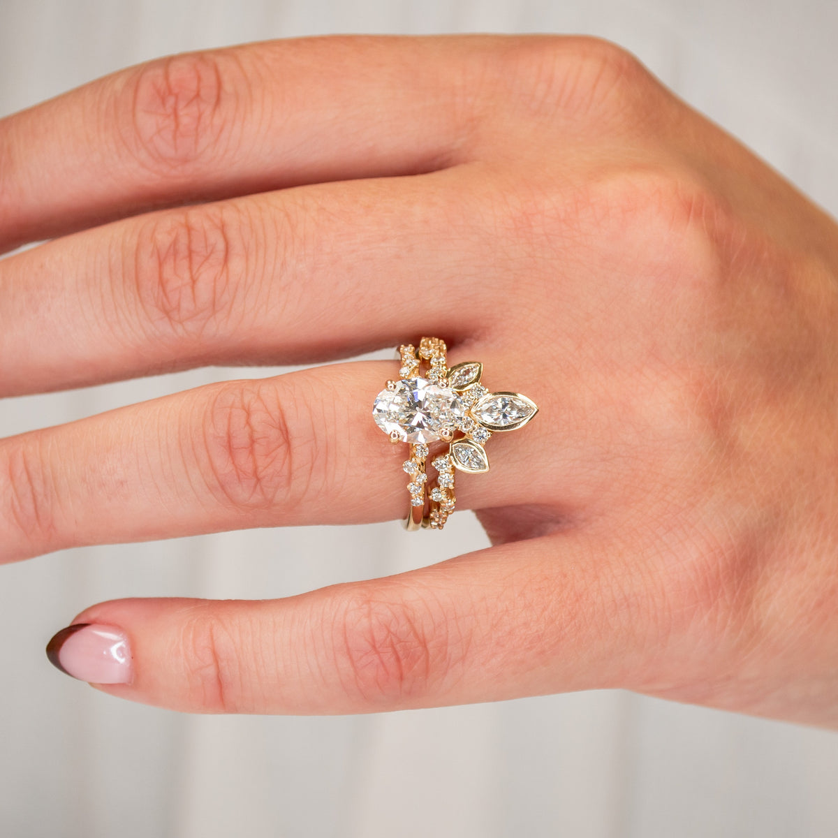 Polaris oval engagement ring in 14K yellow gold with a wedding ring on model by Lisa obin