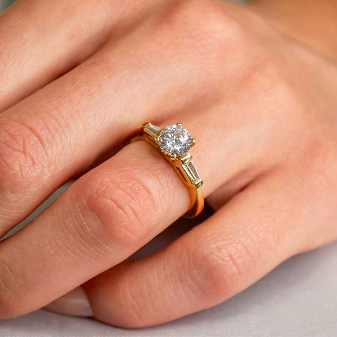 Shown in 1 Carat Diamond*The Devon three stone Engagement Ring with round cut diamond in yellow gold on model hand by Lisa Robin#color_14k-yellow-gold