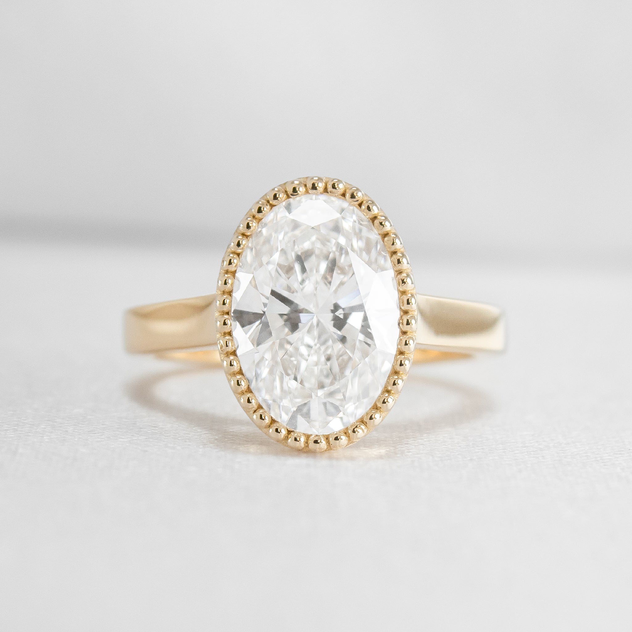 Shown in 3 Carat Diamond*The Ellery Milgrain Bezel Cathedral Engagement Ring with oval cut diamond in yellow gold from front by Lisa Robin#color_14k-yellow-gold