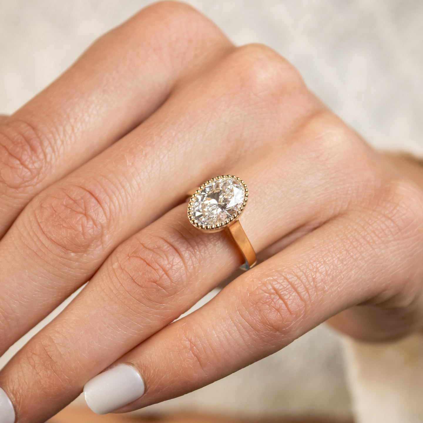 Shown in 3 Carat Diamond*The Ellery Milgrain Bezel Cathedral Engagement Ring with oval cut diamond in yellow gold on model hand by Lisa Robin#color_14k-yellow-gold
