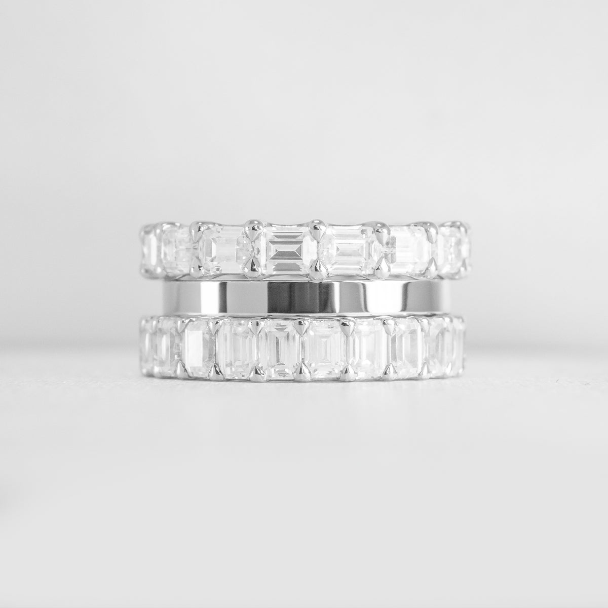The Ensemble Ring Stack Set comprised of the Avery East West Emerald Cut Eternity Diamond Wedding Ring in 14K white gold with Jamie 2mm Wide Flat Wedding Ring in 14K white gold and Aniston Emerald Cut Diamond Eternity Wedding Ring in 14K white gold from front by Lisa Robin#color_14k-white-gold