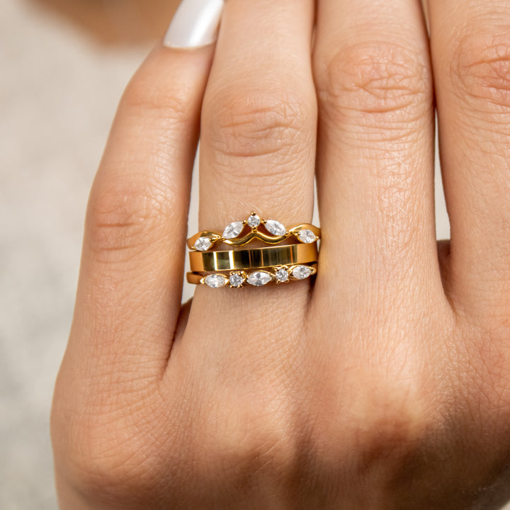 The Ensemble Ring Stack Set comprised of the Evara twist diamond 14K yellow gold wedding ring with Jamie 2.5mm Wide Flat Wedding Ring in 14K yellow gold and Blake Marquise Cut Diamond Wedding Ring in 14K yellow gold on model hand by Lisa Robin Jewelry