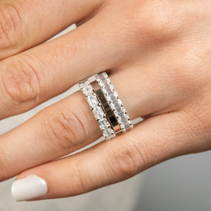 The Ensemble Ring Stack Set comprised of the Lindon Princess Cut diamond Eternity Wedding Band in 14K white gold with Jamie 2mm Wide Flat Wedding Ring in 14K white gold and Aniston Emerald Cut Diamond Eternity Wedding Ring in 14K white gold on model hand by Lisa Robin#color_14k-white-gold