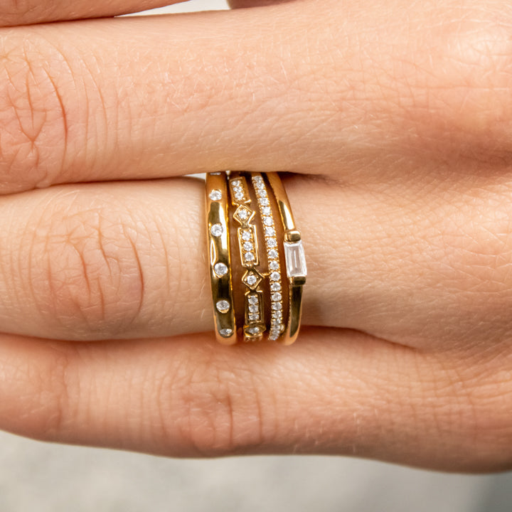 The Ensemble Ring Stack Set comprised of the Dominic Baguette Diamond Wedding Ring in 14K yellow gold with Reese Dome Diamond Wedding Ring in 14K yellow gold and Rene Diamond Wedding Ring in 14K yellow gold on model hand by Lisa Robin#color_14k-yellow-gold