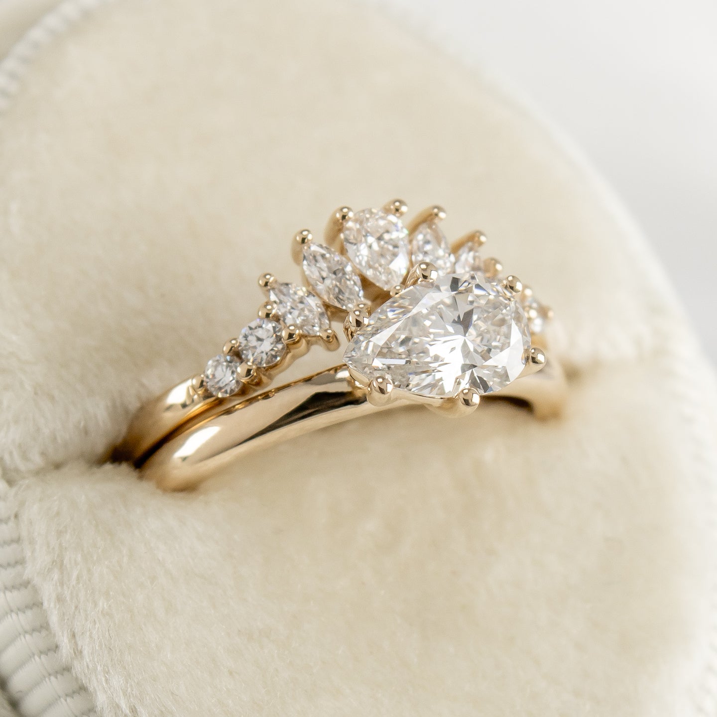 The Gabby curved diamond wedding ring and the Mia pear diamond east west engagement ring both in yellow gold by Lisa Robin