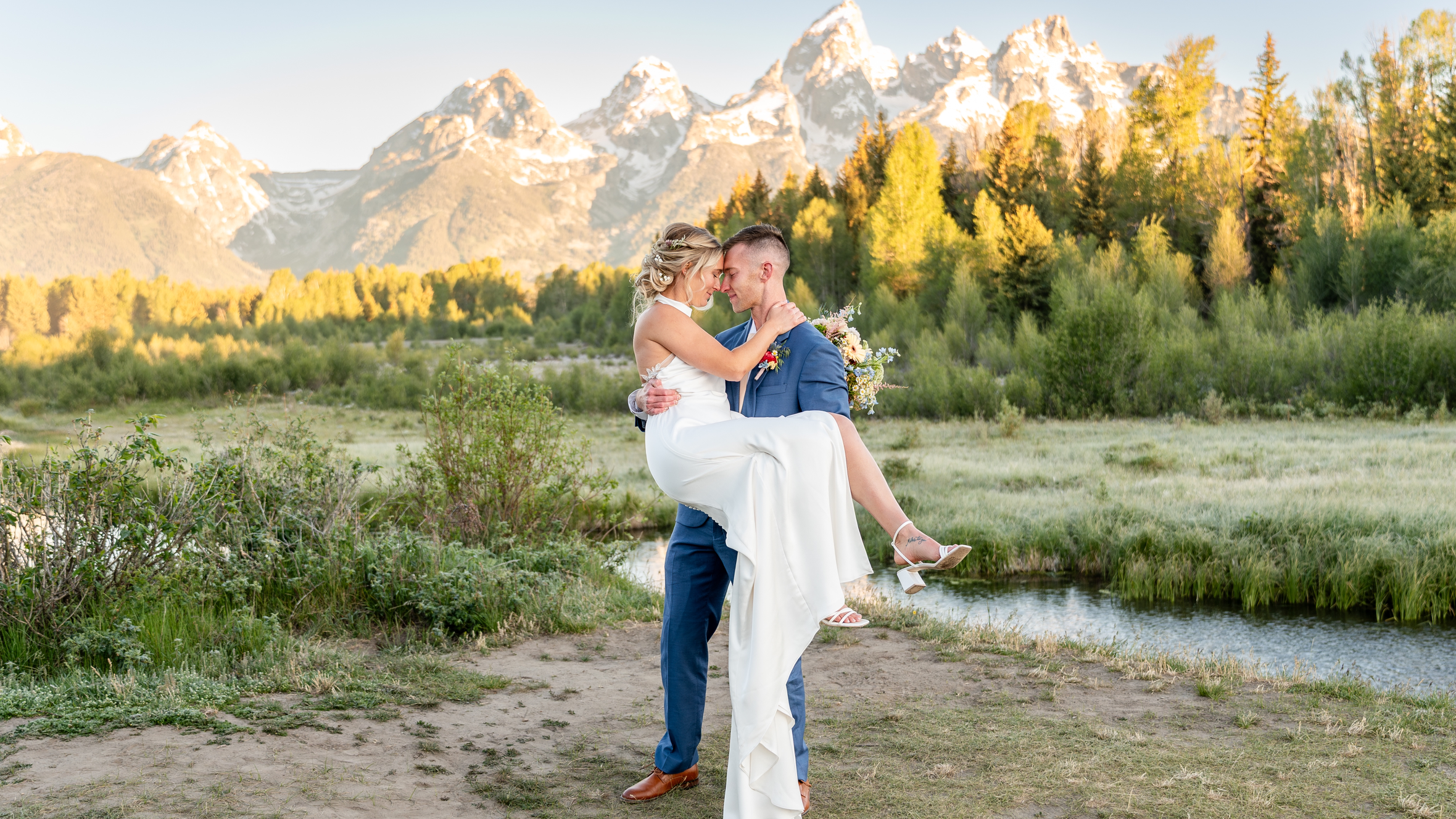 Married couple taking portrait photographs with the groom holding the bride in his arms | Lisa Robin jewelry