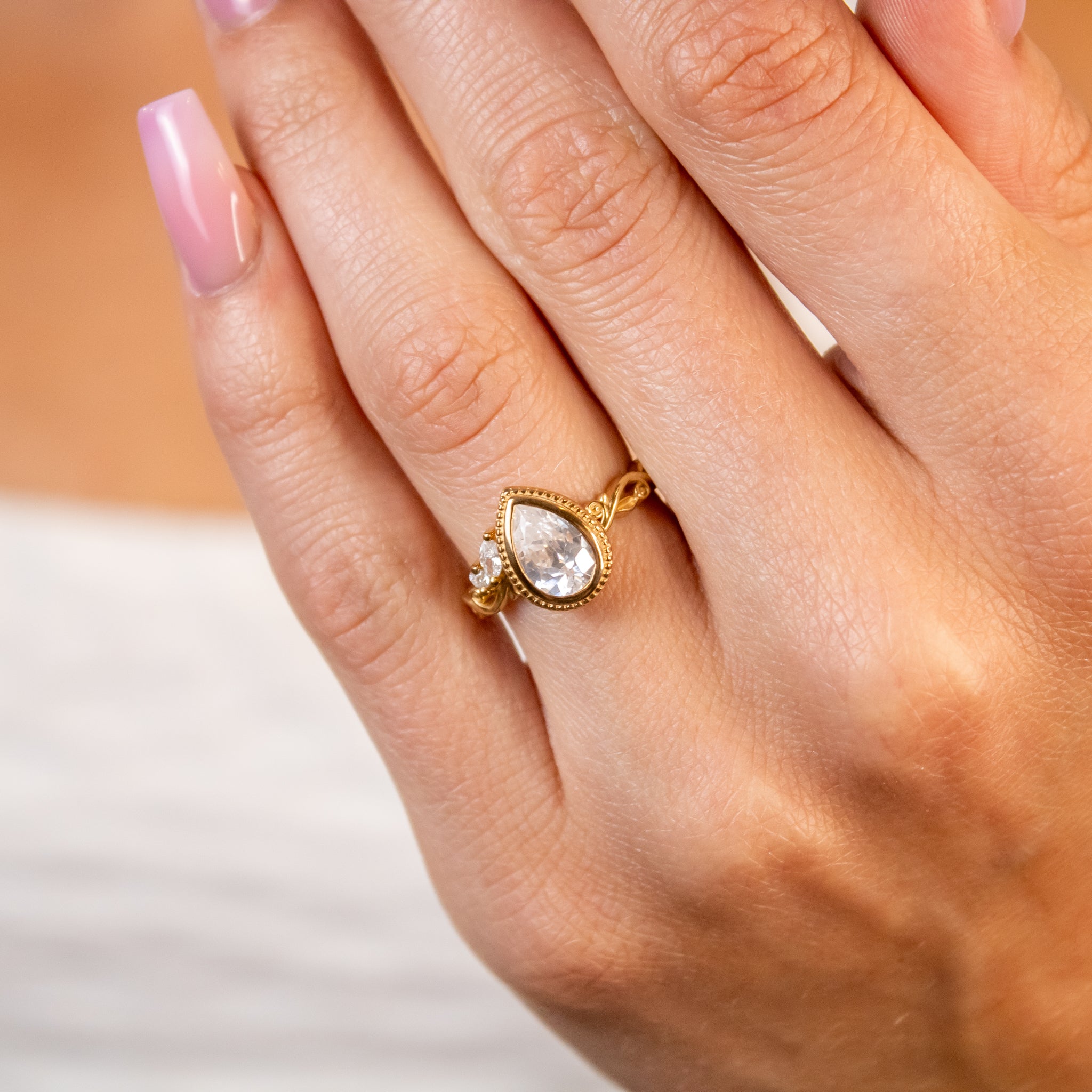 Shown in 1.5 Carat Diamond*The Kallely bezel Diamond Engagement Ring with pear cut diamond in yellow gold on model hand by Lisa Robin#color_14k-yellow-gold