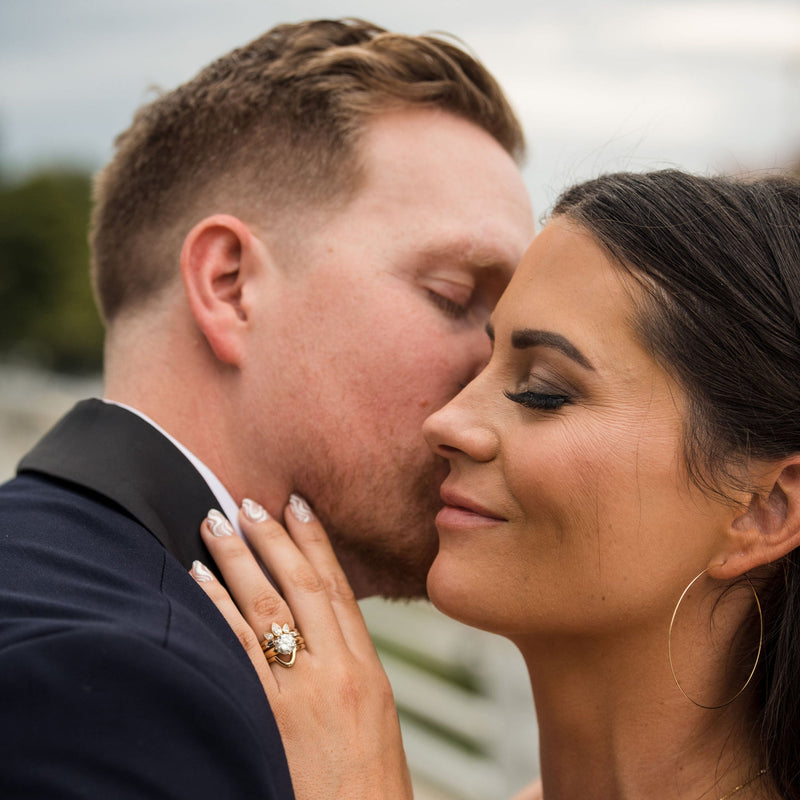 Bride and groom embracing outdoors with a blurred background | Lisa Robin