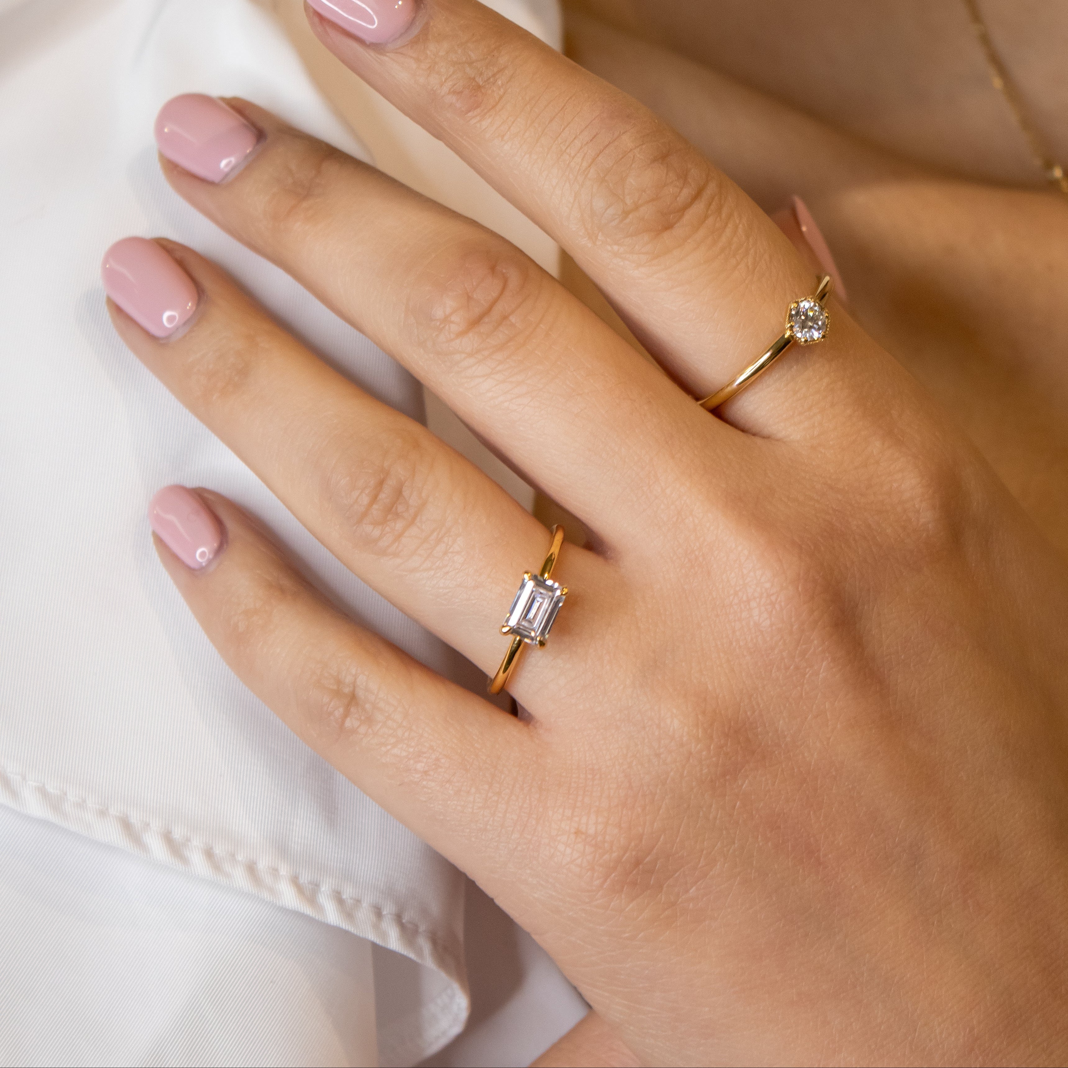 The Mia east west Diamond Engagement Ring with emerald cut diamond in yellow gold on model hand by Lisa Robin Jewelry