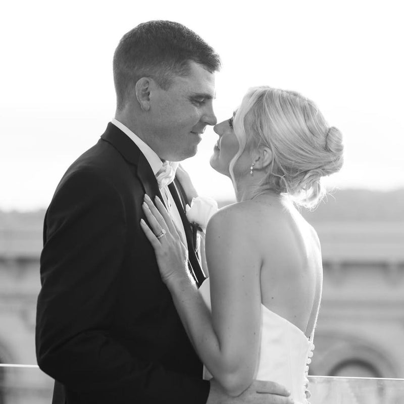 Newlyweds embrasing on rooftop overlooking Coving ton KY and Cincinnati | Lisa Robin