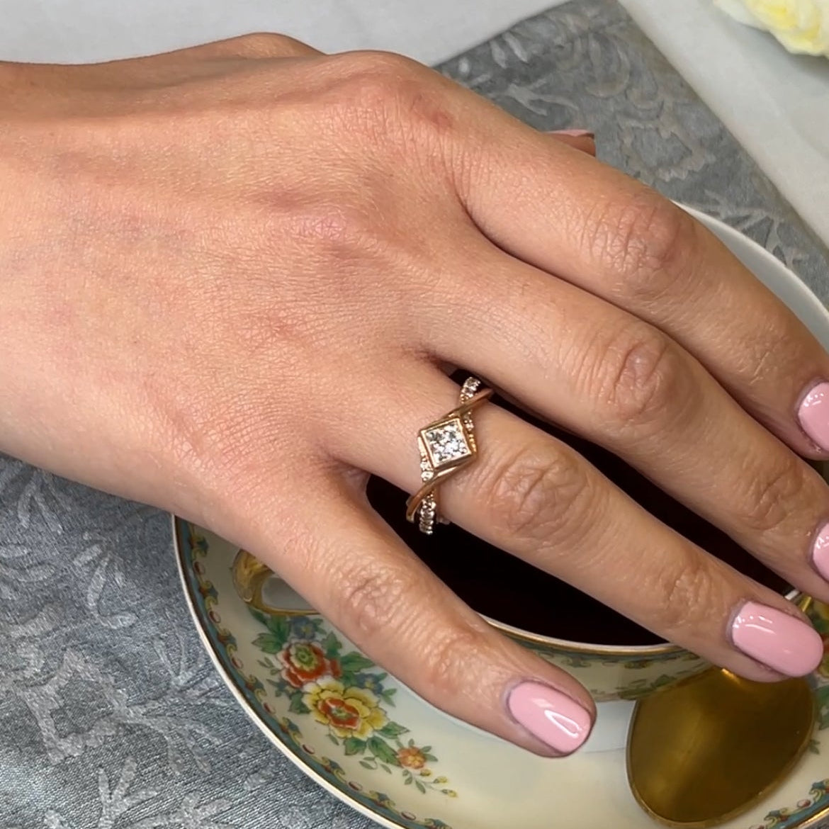 Oakley twist and bezel set princess cut diamond wedding ring by Lisa Robin on model with tea cup#color_14k-rose-gold