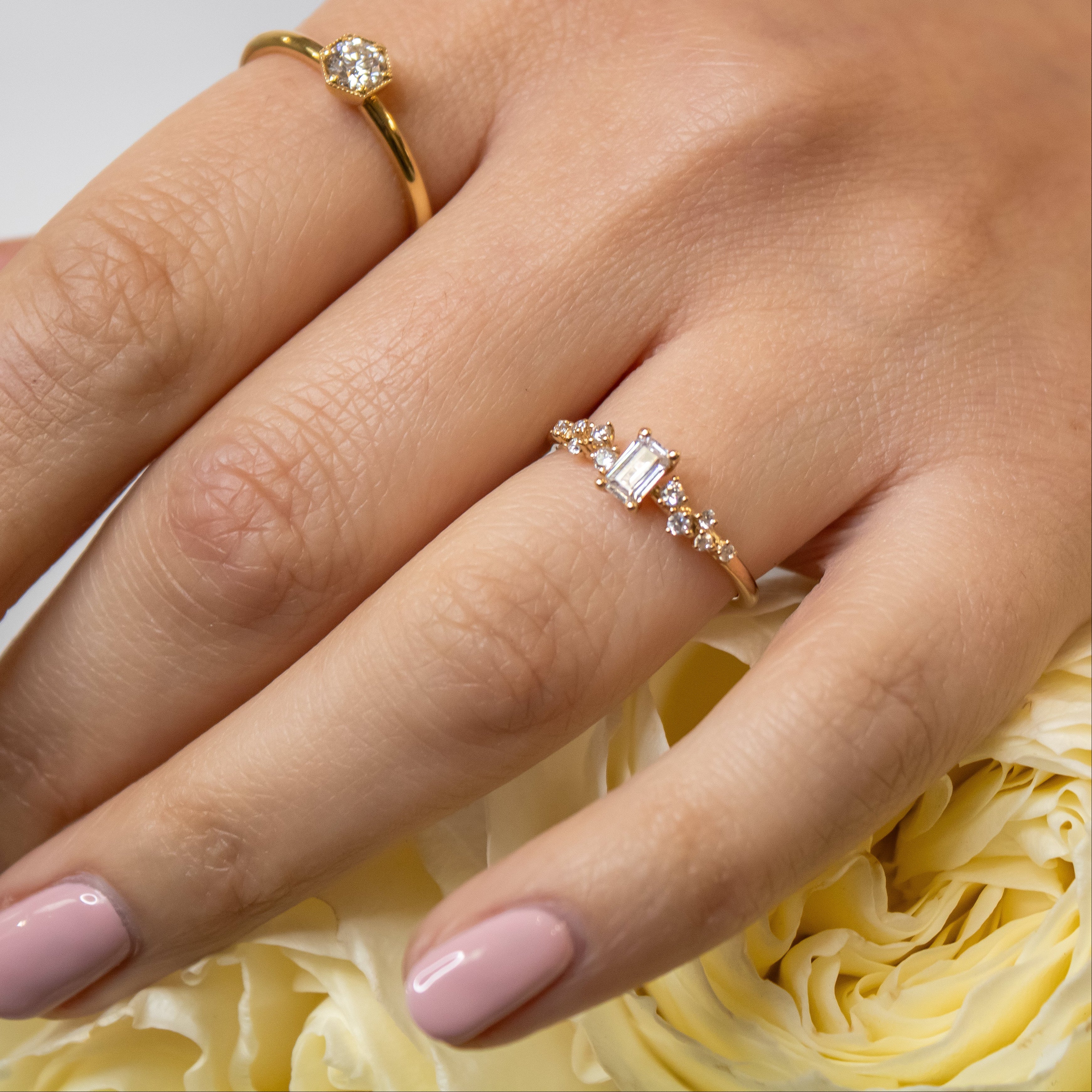 The Polaris Scatter Diamond Engagement Ring with emerald cut diamond in yellow gold on model hand by Lisa Robin Jewelry
