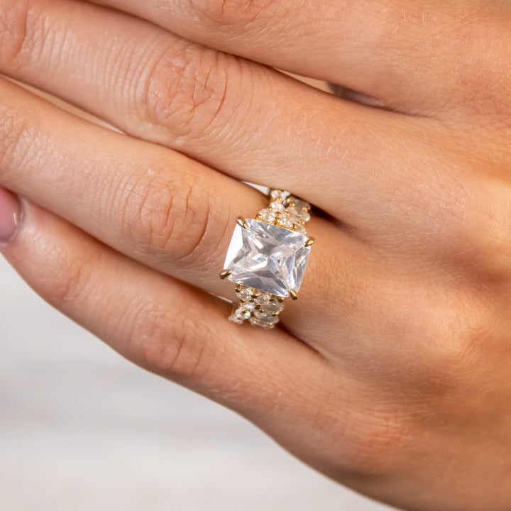 5 carat radiant cut vintage side stone warm yellow gold engagement ring with oval diamond eternity band also in yellow gold on model by Lisa Robin Jewelry