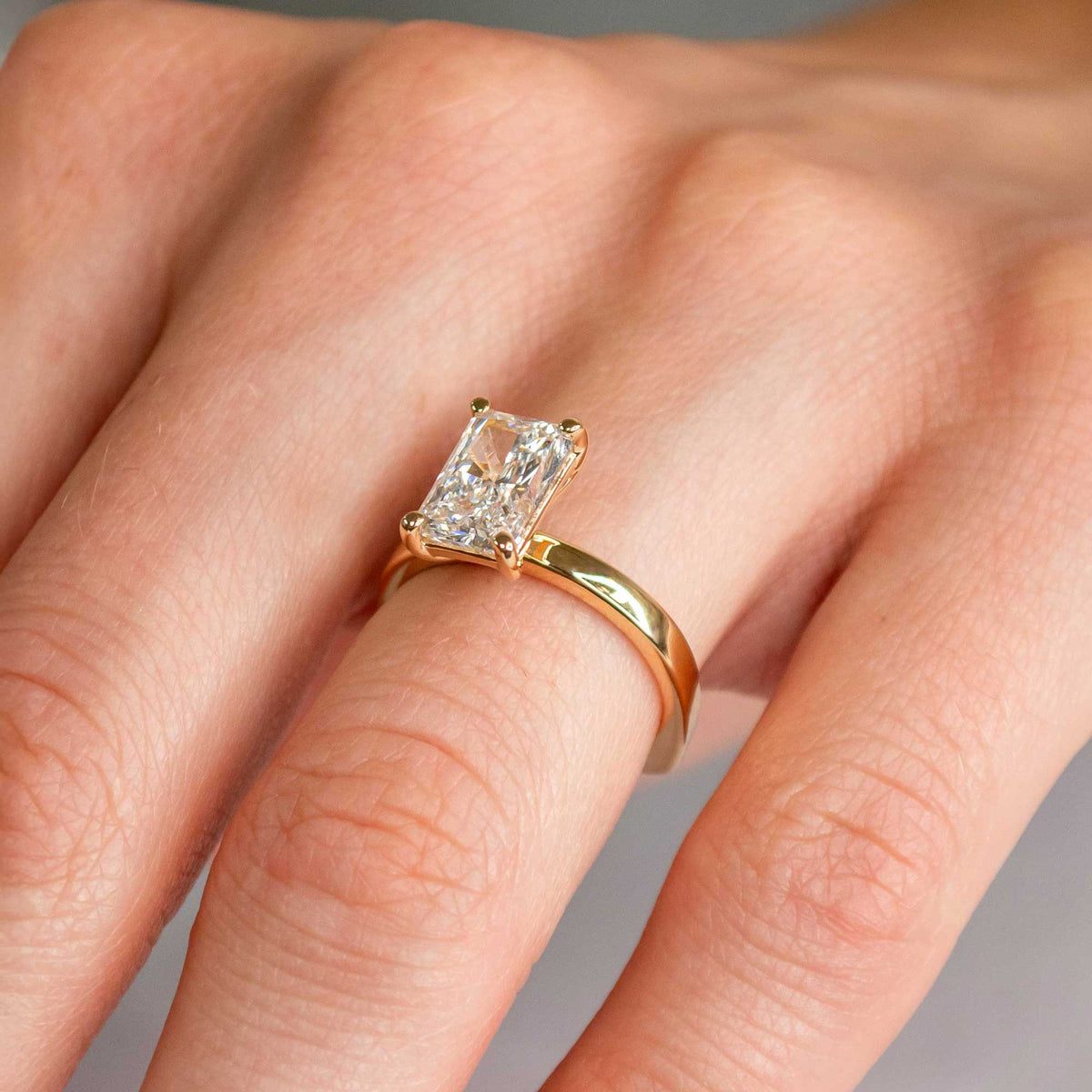 Radiant cut solitaire with bold yellow gold shank on model | Lisa Robin 