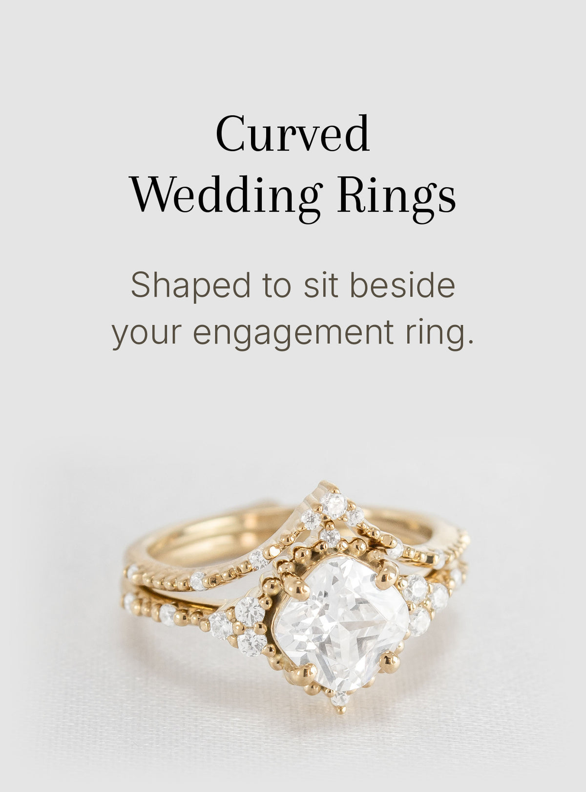 A curved gold wedding ring with a large clear heart-shaped center stone and small clear accent stones, shown below text that reads 'Curved Wedding Rings' and 'Shaped to sit beside your engagement ring.'.