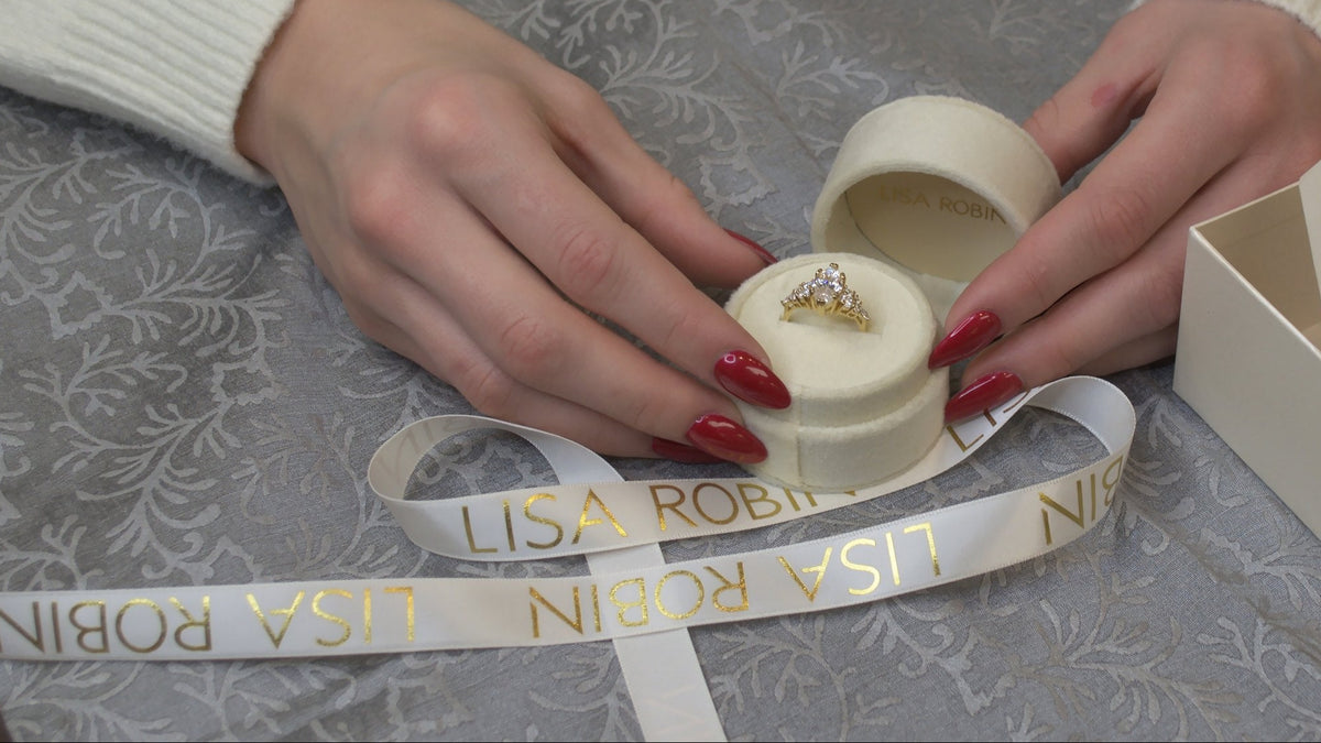 The Dorothy Cluster engagement ring in yellow gold, held in a Lisa Robin velvet ring box