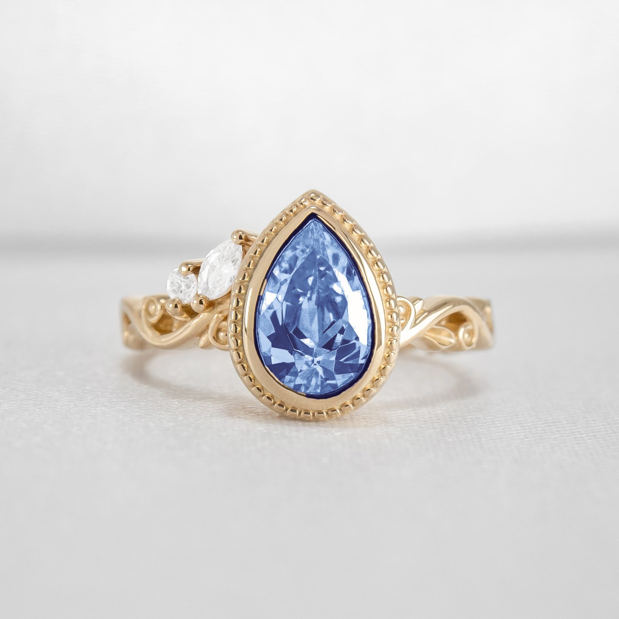 Shown in 2 Carat Blue Diamond*The Fable victorian style bezel Engagement Ring with blue pear cut diamond in yellow gold from front by Lisa Robin#color_14k-yellow-gold
