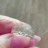 Custom emerald cut and baguette diamond engagement ring held in fingers by Lisa Robin Jewelry