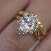 The Ivy Leaf and Vine Halo Diamond Engagement Ring with oval cut diamond in yellow gold paired with The Beatrix Vintage Filigree Engraved Wedding Ring in 14K yellow gold on model hand by Lisa Robin Jewelry
