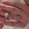 The Dorothy Cluster Diamond Engagement Ring with marquise cut diamond in 14K yellow gold paired with the Marlowe leaf curved open natural diamond 14K yellow gold wedding band on model hand by Lisa Robin Jewelry