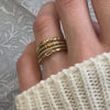 Stack of diamond rings in yellow gold on hand by Lisa Robin