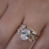 Juniper 3.0 carat oval floral engagement ring in yellow gold and Dillon tapered baguette wedding ring on model from Lisa Robin