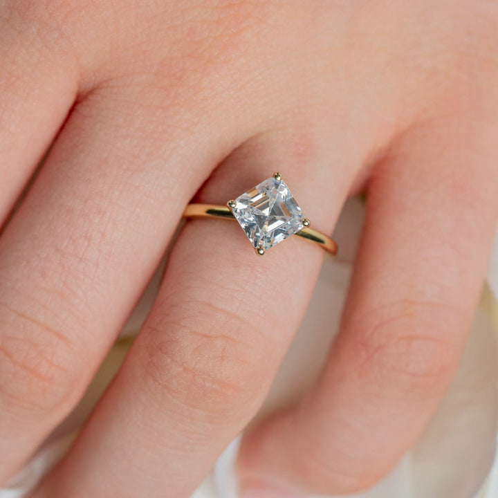 Shown in 2 Carat Diamond*The Stella Compass Set Solitaire Engagement Ring with asscher cut diamond in yellow gold on model hand by Lisa Robin#color_14k-yellow-gold